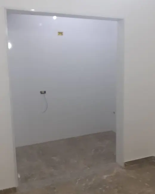 Cômodo com paredes pintadas de branco, rodapé e piso assentados